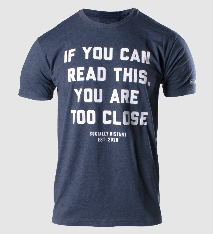 photo of navy tee "if you can read this you are too close " text in white on front. "socially distant est. 2020" in white below. mensa bug icon and text visible on left sleeve.