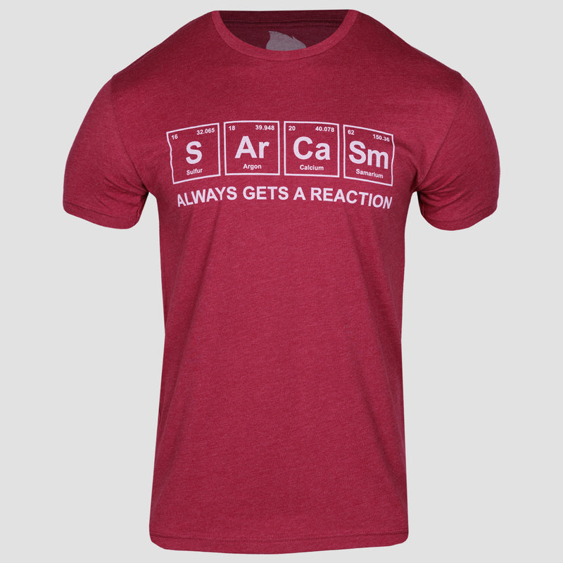 Cardinal unisex sarcasm tee. sarcasm spelled out in periodic elements. S for Sulfur. Ar for Argon. Ca for Calcium. Sm for Samarium. "always get a reaction" text underneath