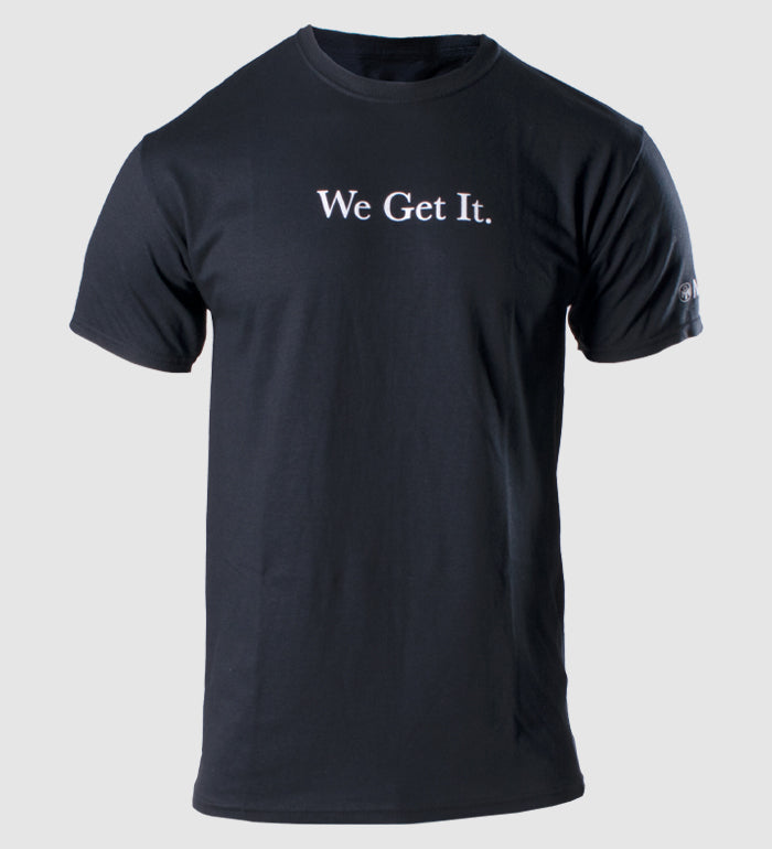 photo of black tee "we get it" text in white on front. mensa logo and bug icon visible on left sleeve.